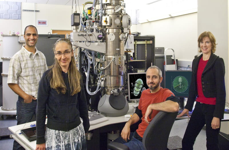 A group of people standing in front of a machine.