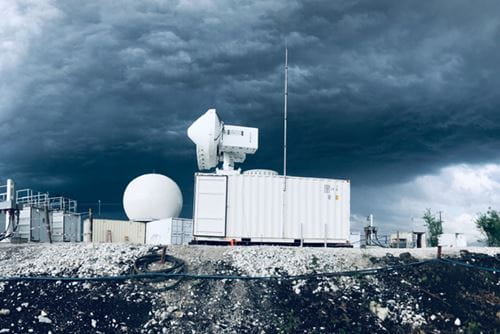 Scanning radars and shipping containers holding ARM's Aerosol Observing System are surrounded by storm clouds in the Sierras de Córdoba mountain range.