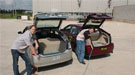 A snapshot of two men charging electric cars.