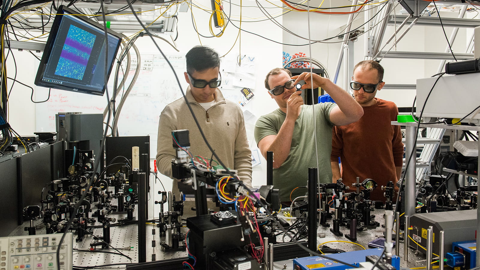 PhD students Kevin Miao, left, Alexandre Bourassa and postdoctoral researcher Sam Bayliss work in Awschalom's lab at the University of Chicago.
