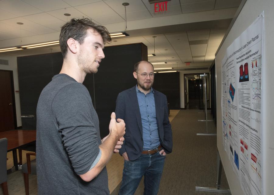 Physicists Jackson Matteucci and Will Fox with poster displaying their research.
