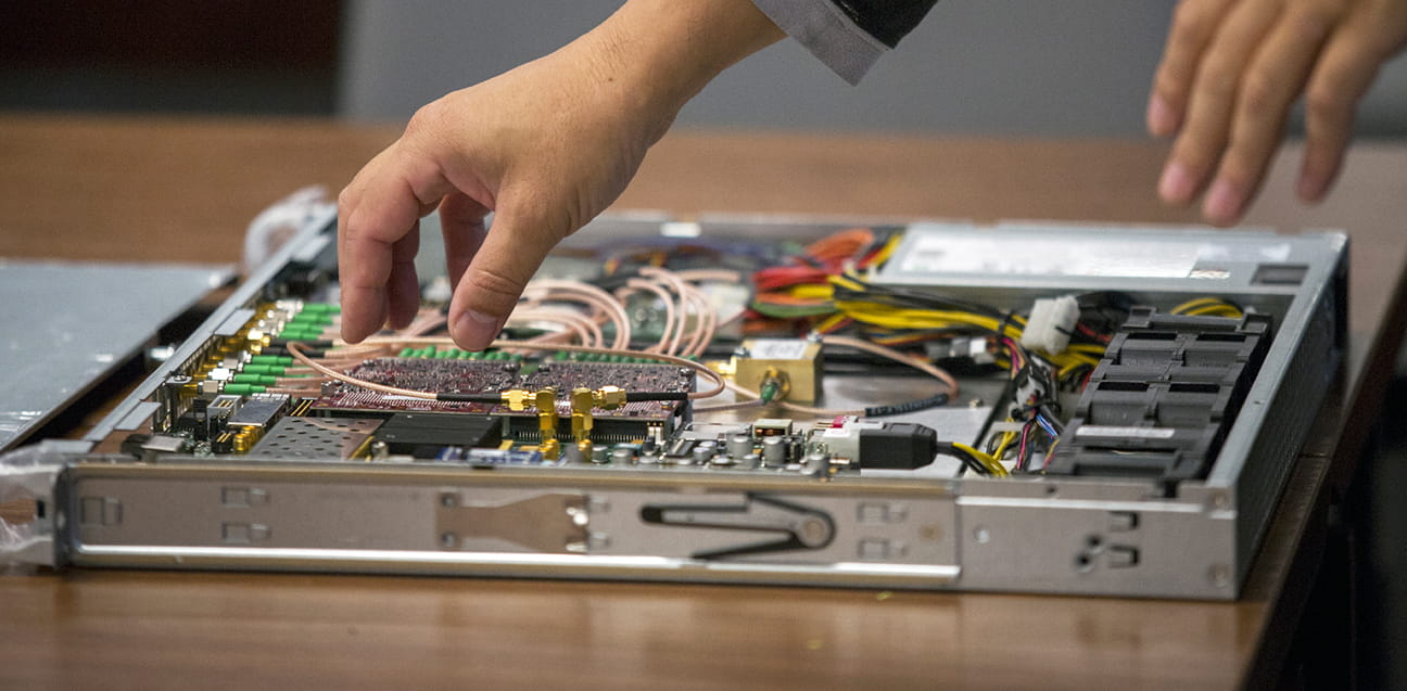 A new FPGA (field programmable gate array) module developed by Gang Huang, a research scientist in Berkeley Lab’s Accelerator Technologies and Applied Physics Division, and Larry Doolittle, a staff engineer in Berkeley Lab’s Engineering Division, for scalable control of superconducting qubits. (Credit: Peter DaSilva/Berkeley Lab)