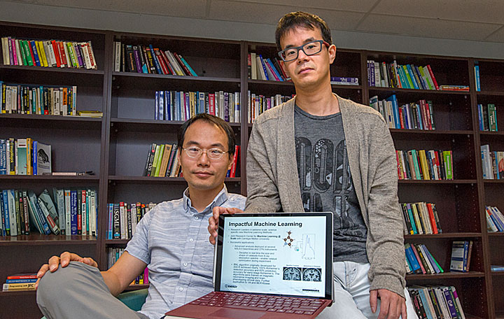 Brookhaven Lab computational scientist Shinjae Yoo (left) and research associate Ji Hwan Park