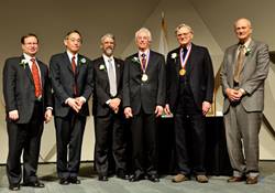 Secretary Chu, Dr. Koonin and Dr. Brinkman with the Fermi award winners wearing their medals and standing on stage
