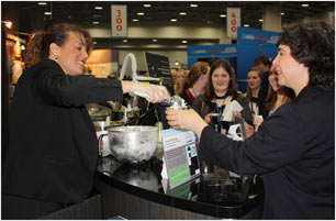 Exhibitor scooping instant ice cream to a passerby with a crowd lined up