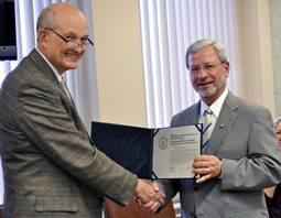 Dr. Brinkman presenting a certificate and shaking hands with Gerald Boyd