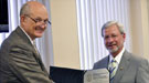 Dr. Brinkman presenting a certificate and shaking hands with Gerald Boyd