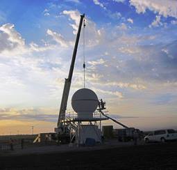 A crane positions the topmost portion of the X-band scanning ARM precipitation radar (X-SAPR).
