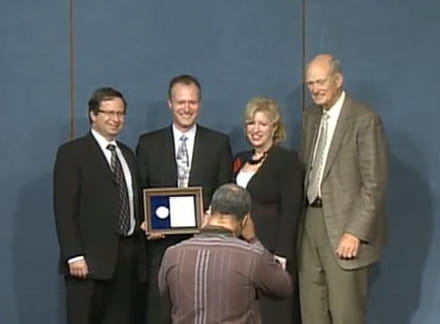 Senior leadership with a PECASE winner posing for a photograph