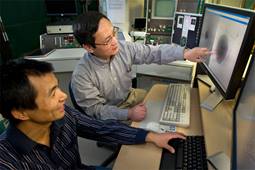 Scientists Jingchuan (Jim) Sun and Huilin Li sitting at a computer in the lab looking at an image on the monitor