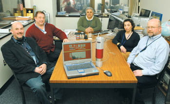Team of engineers sitting around a table with the MINDS device
