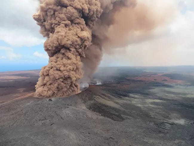 A huge plume of brown smoke emerging from a volcano